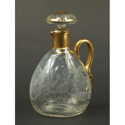 3920 - Continental glass decanter with gilt handle etched with a stag, buildings and flowers, 22.5cm high