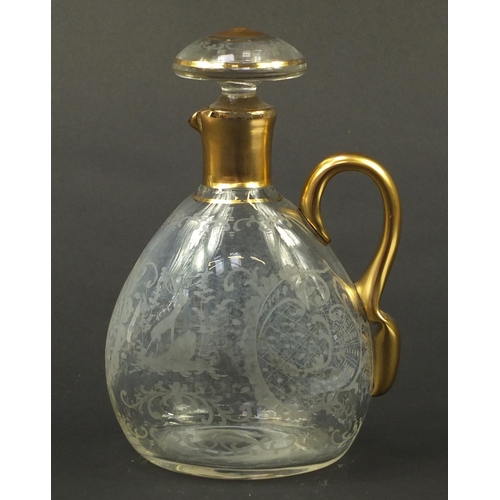 3920 - Continental glass decanter with gilt handle etched with a stag, buildings and flowers, 22.5cm high