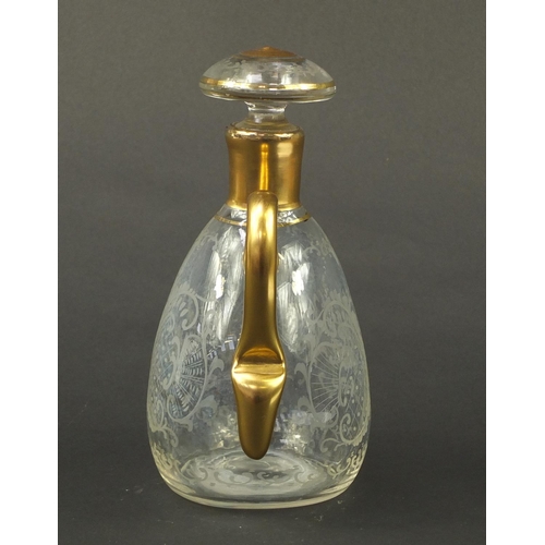 3920 - Continental glass decanter with gilt handle etched with a stag, buildings and flowers, 22.5cm high