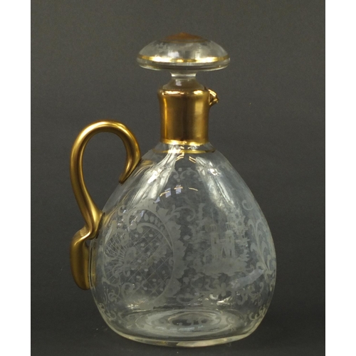 3920 - Continental glass decanter with gilt handle etched with a stag, buildings and flowers, 22.5cm high