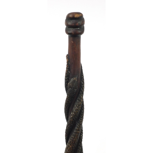 3844 - Tribal interest walking stick with figural pommel, carved with serpents, 92cm in length