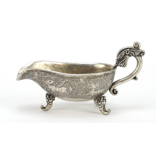 3568 - Chinese silver coloured metal sauce boat, decorated with mythical beasts, character marks to the bas... 