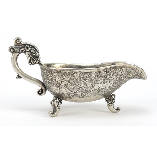 3568 - Chinese silver coloured metal sauce boat, decorated with mythical beasts, character marks to the bas... 