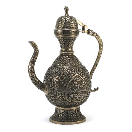 4133 - Indian silver coloured metal wine ewer embossed and engraved with flowers, 36cm high