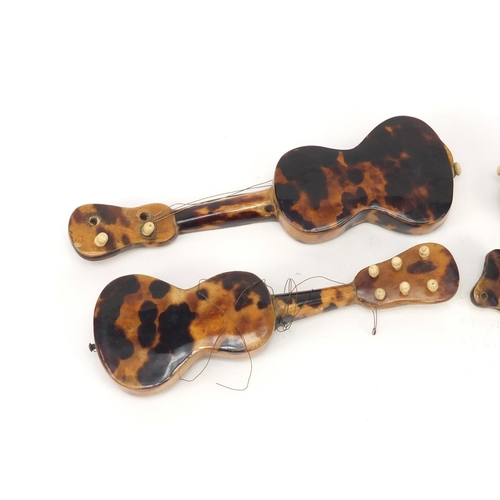 3994 - Four tortoiseshell and mother of pearl musical instruments comprising two guitars and two mandolins,... 