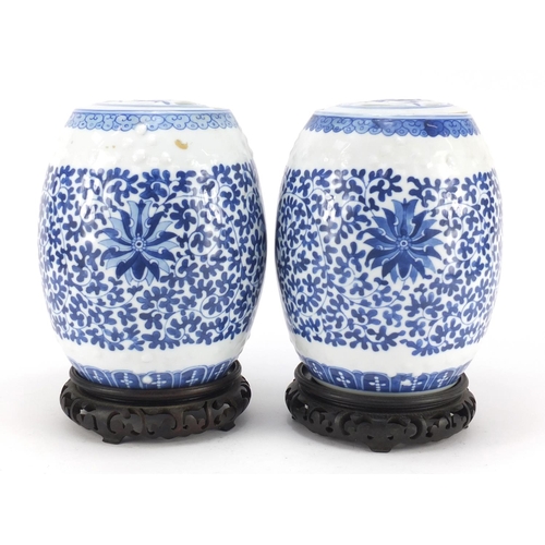 3042 - Pair of Chinese blue and white porcelain jars and covers raised on hardwood stands, each hand painte... 