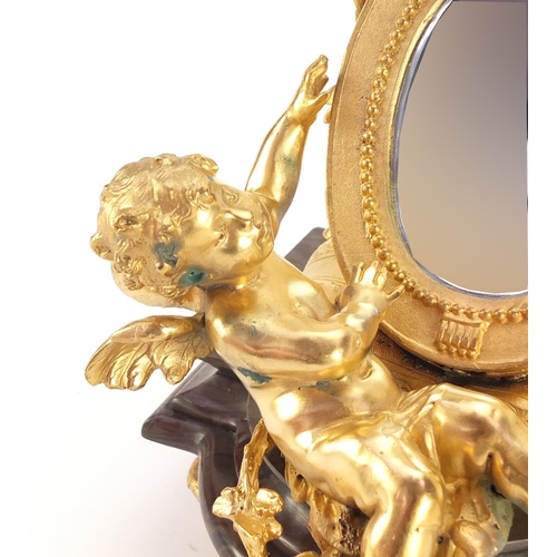 4003 - French Empire style gilt bronze table mirror in the form of putti with a mandolin, raised on a shape... 