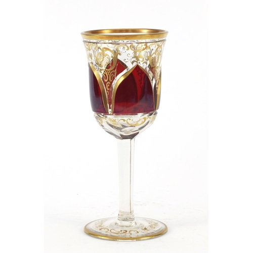 3917 - Bohemian red flashed glass goblet gilded with foliage, 20.5cm high