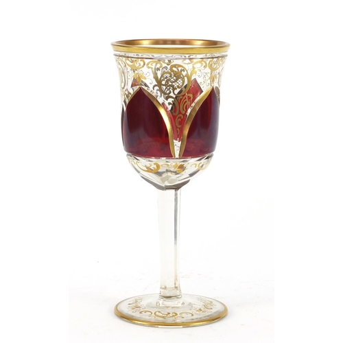 3917 - Bohemian red flashed glass goblet gilded with foliage, 20.5cm high