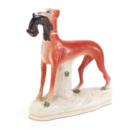 1179 - Staffordshire pottery whippet with game, 19cm high