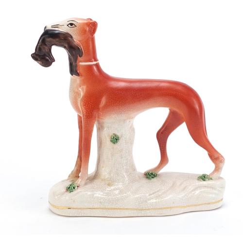 1179 - Staffordshire pottery whippet with game, 19cm high