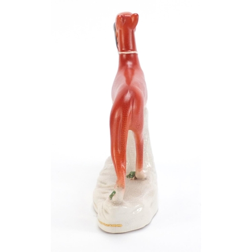 1179 - Staffordshire pottery whippet with game, 19cm high