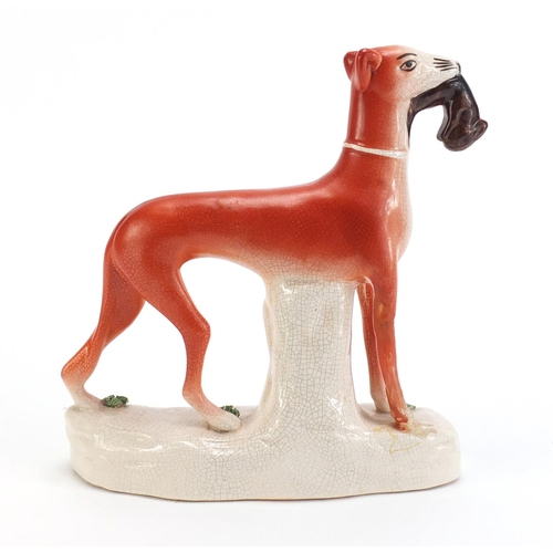 1179 - Staffordshire pottery whippet with game, 19cm high