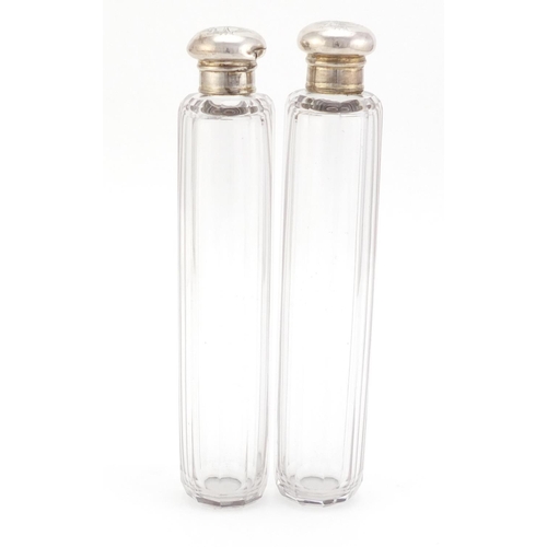 1490 - Pair of cut glass bottles with silver lids, each 18.5cm in length