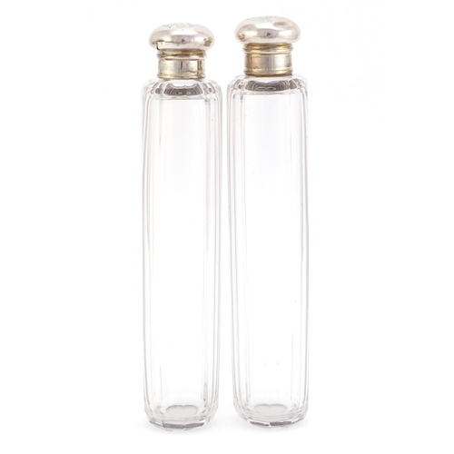 1490 - Pair of cut glass bottles with silver lids, each 18.5cm in length