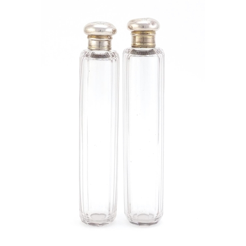 1490 - Pair of cut glass bottles with silver lids, each 18.5cm in length