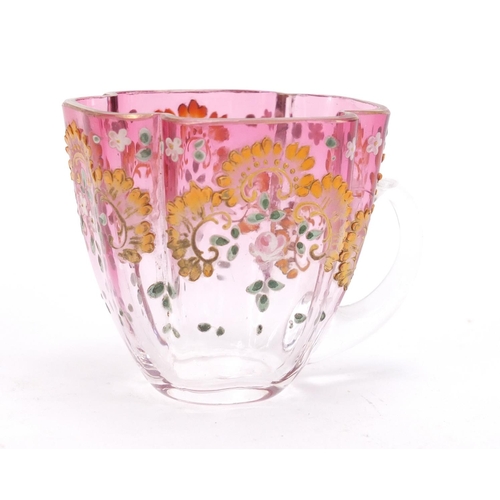 1492 - Continental glass cup and saucer enamelled with flowers, the saucer 13cm wide