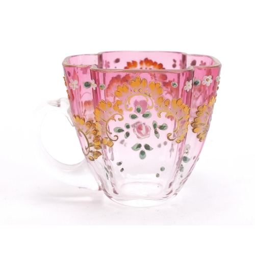 1492 - Continental glass cup and saucer enamelled with flowers, the saucer 13cm wide