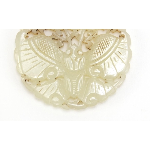 838 - Chinese pale jade disc, pierced and carved with a bat and flowers, 5.5cm in diameter