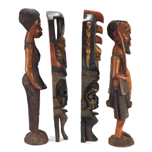 1507 - Four tribal wood carvings including a tribesman and two face masks, the largest 60cm high