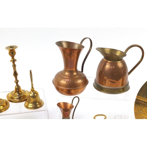 1413 - Copper and brassware including jugs and pair of candlesticks, the largest 25.5cm in diameter