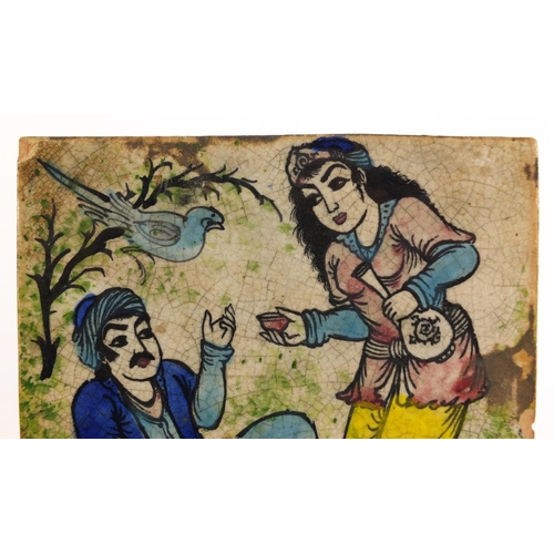 517 - Islamic pottery tile hand painted with two figures and a bird, 24.5cm X 24.5cm