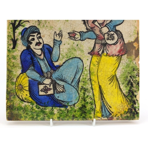 517 - Islamic pottery tile hand painted with two figures and a bird, 24.5cm X 24.5cm