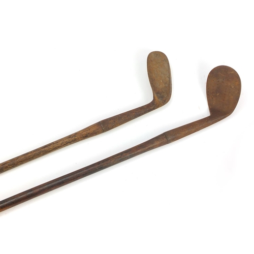 604 - Two wooden shafted Niblick golf clubs including one stamped Eastbourne, the largest 97cm in length