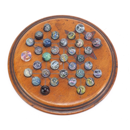 713 - 19th century solitaire board and a selection of mostly swirl marbles, the board 19.5cm in diameter