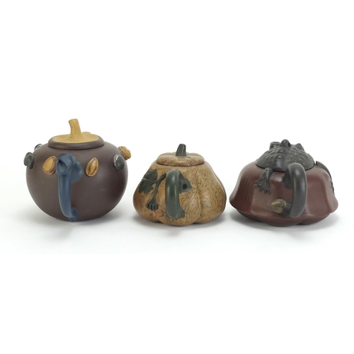 129 - Three Chinese Yixing terracotta teapots including a toad design example, each with impressed charact... 