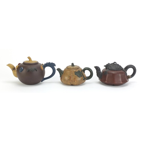 129 - Three Chinese Yixing terracotta teapots including a toad design example, each with impressed charact... 