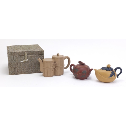 835 - Three Chinese Yixing teracotta teapots including one in the form of a yellow peach and another hand ... 