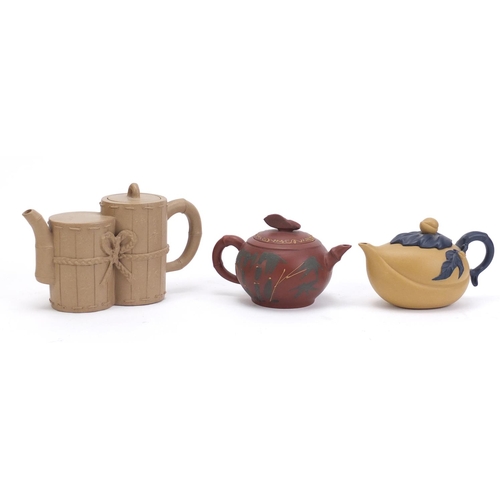 835 - Three Chinese Yixing teracotta teapots including one in the form of a yellow peach and another hand ... 