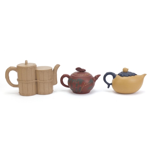 835 - Three Chinese Yixing teracotta teapots including one in the form of a yellow peach and another hand ... 