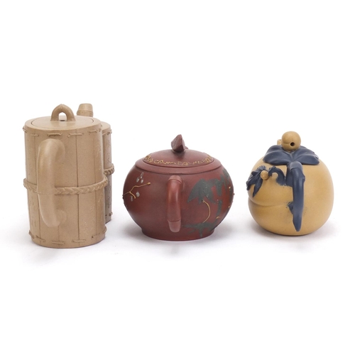 835 - Three Chinese Yixing teracotta teapots including one in the form of a yellow peach and another hand ... 