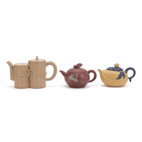 835 - Three Chinese Yixing teracotta teapots including one in the form of a yellow peach and another hand ... 