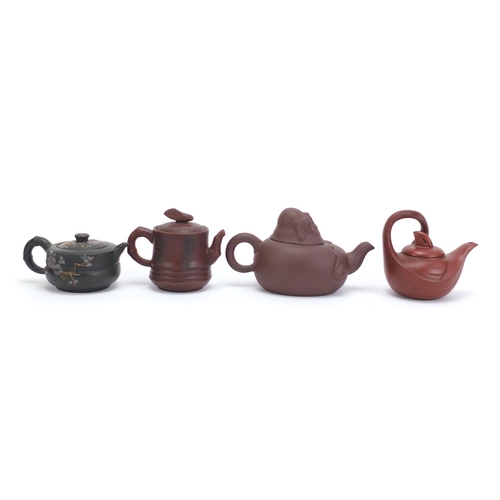 228 - Four Chinese Yixing teracotta teapots comprising one in the form of a smiling Buddha, another in the... 