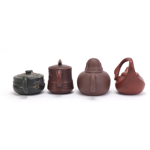 228 - Four Chinese Yixing teracotta teapots comprising one in the form of a smiling Buddha, another in the... 