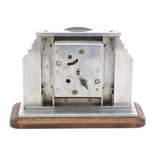 246 - Silvered mantel clock having Roman numerals, engraved with a Dutch landscape, raised on an oak plint... 