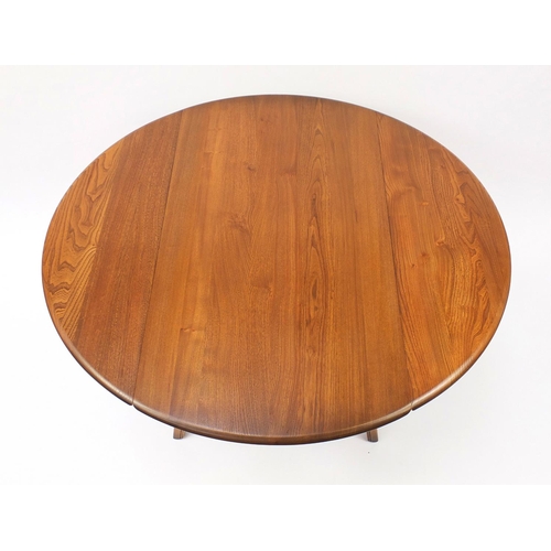 1587 - Ercol elm dining table and four chairs, the table 72cm high x 113cm deep when closed