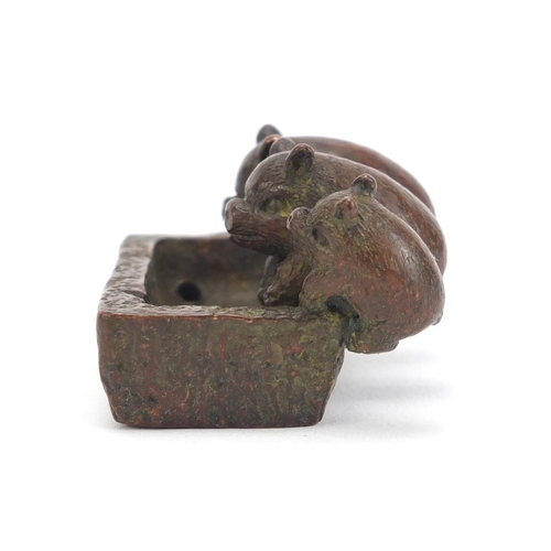 636 - Japanese patinated bronze okimono of three piglets in a trough, impressed character marks to the bas... 