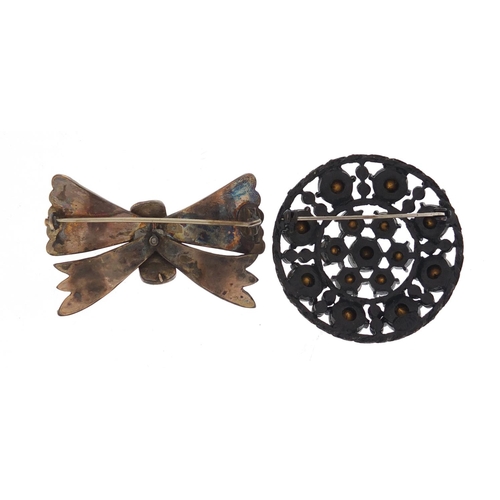 1304 - Victorian garnet bow brooch and a jet design brooch, the largest 5cm in length