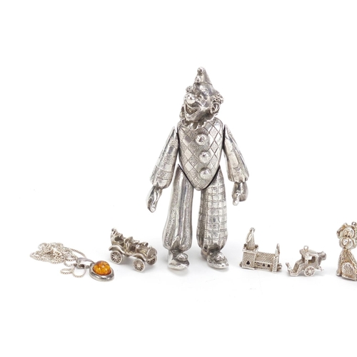 972 - Silver charms, amber pendant and a silver plated articulated clown, 10cm high