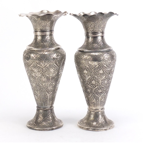 515 - Pair of Persian silver vases profusely engraved with flowers, 22cm high, 480.0g