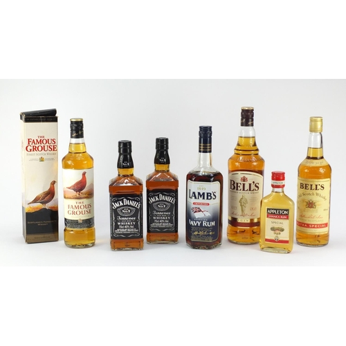 73 - Seven bottles of whiskey and rum including 1L Bells, two bottles of Jack Daniels, The Famous Grouse ... 