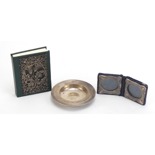 814 - Silver items comprising a circular dish, silver fronted address book and a folding double frame, the... 