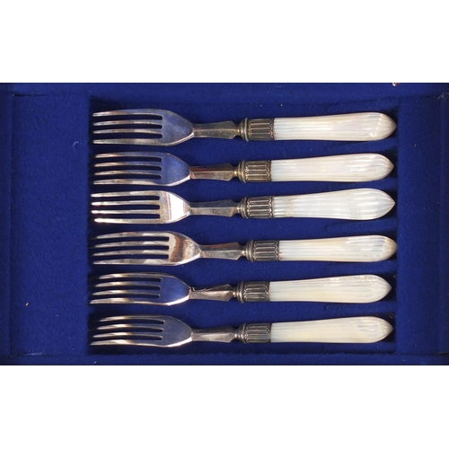 822 - Set of six silver plated cake knives and forks with mother of pearl handles, housed in a fitted waln... 