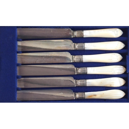 822 - Set of six silver plated cake knives and forks with mother of pearl handles, housed in a fitted waln... 