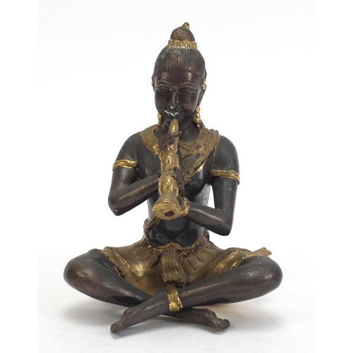 888 - Asian partially gilt bronze figure of a female playing a flute, 15cm high