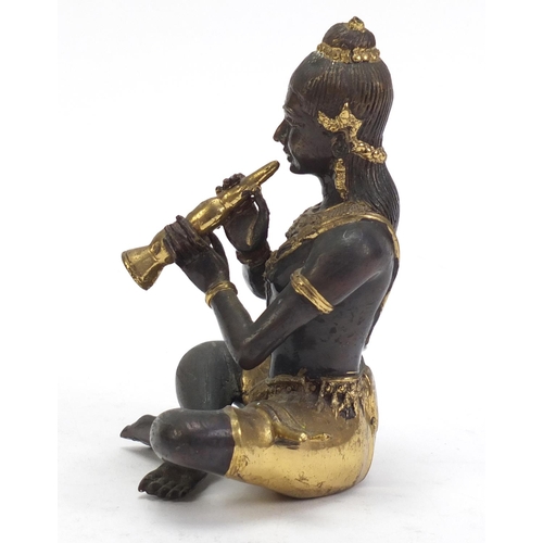 888 - Asian partially gilt bronze figure of a female playing a flute, 15cm high